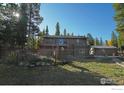 Spacious backyard featuring a deck, storage building, and fenced area, perfect for outdoor living at 10649 Christopher Dr, Conifer, CO 80433