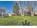 Picture of large grassy yard with mature trees and camper parked on the side at 1098 Cherryvale Rd, Boulder, CO 80303