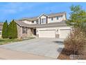 Attractive home with a large driveway leading to a three-car garage and partial stone facade at 11676 Montgomery Cir, Longmont, CO 80504