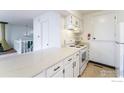 Kitchen featuring quartz countertops and white cabinets, seamlessly connects to the adjacent living area at 1225 Centaur Cir # A, Lafayette, CO 80026