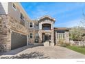 Stunning exterior featuring stone accents, gray siding, a spacious driveway, and meticulous landscaping at 14295 Lipan St, Westminster, CO 80023