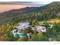 Stunning aerial view of a luxury home with a pool surrounded by lush greenery at 1530 Timber Ln, Boulder, CO 80304