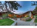Beautiful exterior featuring stone accents, lush landscaping and exterior lighting at 1530 Timber Ln, Boulder, CO 80304