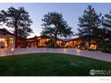 Stunning exterior elevation of a modern mountain home featuring a beautiful driveway, lush lawn and mature trees at 1530 Timber Ln, Boulder, CO 80304