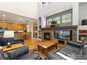 Bright living room featuring a stone fireplace, hardwood floors, and an open layout leading to the kitchen at 1619 Bluefield Ave, Longmont, CO 80504