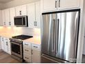 Updated kitchen with stainless steel appliances and sleek, white cabinetry provides a modern, stylish space at 193 Liberty St, Erie, CO 80516
