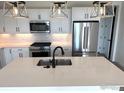 Modern kitchen featuring an island with a stainless steel sink, and stainless steel appliances at 193 Liberty St, Erie, CO 80516