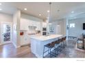 Spacious kitchen featuring a large center island, white cabinets, and a view into the living area at 21574 E 59Th Dr, Aurora, CO 80019