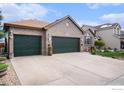 Charming brick home with a three-car garage and well-manicured lawn, featuring professional landscaping and mature plantings at 2190 Coyote Creek Dr, Fort Lupton, CO 80621