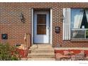 Close-up of the home's front door, brickwork, and adjacent window with white shutters and updated fixtures at 3190 Stanford Ave, Boulder, CO 80305