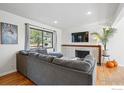 Cozy living room featuring a brick fireplace, hardwood floors, and a comfortable sectional sofa at 3190 Stanford Ave, Boulder, CO 80305