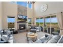 Open-concept living room with a cozy fireplace, high ceilings, and scenic views at 3304 Heron Lakes Pkwy, Berthoud, CO 80513