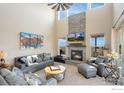 Spacious living area with fireplace, plush seating, and bright natural light from the windows at 3304 Heron Lakes Pkwy, Berthoud, CO 80513