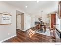 Dining space with wood floors, decorative lighting, and an open view to the living area at 4774 Coker Ave, Castle Rock, CO 80104