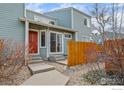 Inviting front entrance with a vibrant red door, concrete steps, and well-kept landscaping at 5146 Buckingham Rd, Boulder, CO 80301