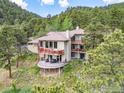 Expansive home exterior showcases balconies and a patio, complemented by the surrounding natural landscape at 524 Cutter Ln, Boulder, CO 80302
