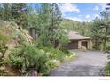 Stunning home exterior featuring a three-car garage, well-manicured landscaping, and a private driveway at 524 Cutter Ln, Boulder, CO 80302