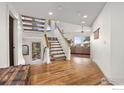 Bright foyer with hardwood floors, an open staircase, and views into the adjacent living area at 524 Cutter Ln, Boulder, CO 80302