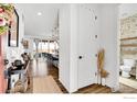 Bright entryway with hardwood floors, a white door, and a view into the open-concept kitchen at 6163 Easton Cir, Frederick, CO 80504