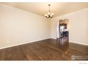 Bright dining room with hardwood floors, chandelier, and view into the kitchen with stainless steel appliances at 6709 2Nd St, Frederick, CO 80530