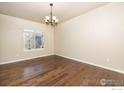 Inviting dining room with hardwood floors, chandelier, and a bright window offering a pleasant view at 6709 2Nd St, Frederick, CO 80530