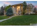 Elegant home featuring a beautiful stone facade and lush green lawn at 787 Niwot Ridge Ln, Lafayette, CO 80026