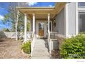 Inviting front porch with classic white columns and well-maintained landscaping at 9960 Bountiful St, Firestone, CO 80504