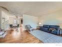 Bright and airy living room with hardwood floors and adjacent dining area at 1011 Glenwood Dr, Lafayette, CO 80026