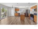 Spacious kitchen with an island, stainless steel appliances, wood cabinets, and access to a backyard patio at 10703 Butte Dr, Longmont, CO 80504