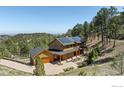 Picturesque home with an attached garage, solar panels, and a circular driveway at 1472 Timber Ln, Boulder, CO 80304