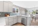 Well-lit kitchen with white cabinets, quartz countertops, and stainless steel appliances and view to dining nook at 1485 Stoneham St, Superior, CO 80027