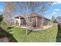 This home features a large backyard, a wooden patio area, and lots of open green space at 1511 Bowen St, Longmont, CO 80501