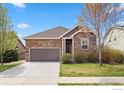 Charming single-Gathering home featuring stone accents, a well-maintained lawn, and an attached two-car garage at 1511 Bowen St, Longmont, CO 80501
