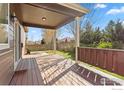 Inviting covered patio with wood flooring and decorative wood railing overlooking backyard at 1511 Bowen St, Longmont, CO 80501
