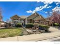 Attractive home exterior featuring a manicured front yard, blooming trees, and charming curb appeal at 1568 Stardance Cir, Longmont, CO 80504