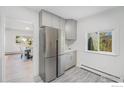 Modern kitchen area featuring stainless steel refrigerator and view into the dining room at 1580 S Krameria St, Denver, CO 80224