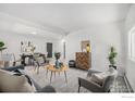 Spacious living area with coordinated furniture, wood floors, and a dining area, perfect for modern living at 1580 S Krameria St, Denver, CO 80224