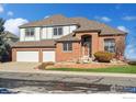 Charming two-story brick home with a three-car garage and beautifully landscaped front yard at 16261 W Ellsworth Ave, Golden, CO 80401