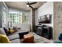 Comfortable living room features a large window, modern ceiling fan, and an entertainment center with a fireplace at 1700 Bassett St # 409, Denver, CO 80202