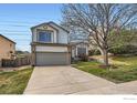 Two-story home featuring a two-car garage, brick accents, and a well-maintained front lawn at 21656 Hill Gail Way, Parker, CO 80138