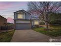 Two-story home featuring a two-car garage, brick accents, and a well-maintained front lawn at 21656 Hill Gail Way, Parker, CO 80138