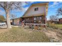 Charming two-story home featuring a front porch with decorative details and mature trees at 2226 Judson St, Longmont, CO 80501