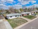 Lovely home with a gray roof, white painted brick, green door, attached carport and mature trees at 2566 S Stuart St, Denver, CO 80219