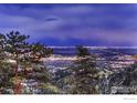 Beautiful city lights sparkle at night as seen from a mountaintop vantage point surrounded by lush trees at 36 High View Dr, Boulder, CO 80304