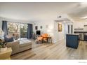 Open-concept living area with wood floors, access to a balcony, and a view of the kitchen at 5120 Williams Fork Trl # 214, Boulder, CO 80301