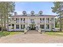 Stately two-story home featuring a covered entry, manicured landscaping, and symmetrical design at 5800 Saint Vrain Rd, Longmont, CO 80503