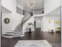 Bright open foyer boasting a curved staircase, dark wood floors, stylish chandelier, and decorative accents at 5800 Saint Vrain Rd, Longmont, CO 80503