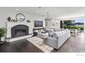 Sophisticated living room with a cozy fireplace, dark floors, stylish furnishings, and access to the outdoor patio at 5800 Saint Vrain Rd, Longmont, CO 80503