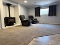 Basement featuring a cozy fireplace, plush carpeting, and comfortable recliners for relaxation at 647 Buchanan Ln, Longmont, CO 80504