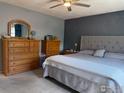 Comfortable bedroom with soft carpeting, light grey walls, and dark grey accent wall at 647 Buchanan Ln, Longmont, CO 80504